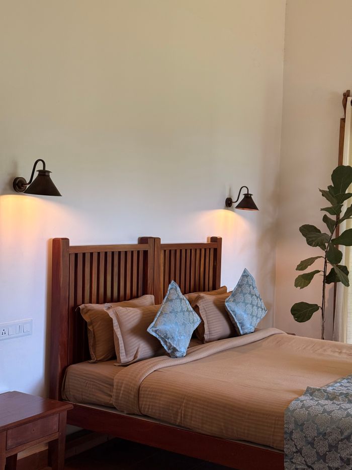 Cozy and elegant bedroom interior with wooden bed, soft lighting, and decorative pillows.
