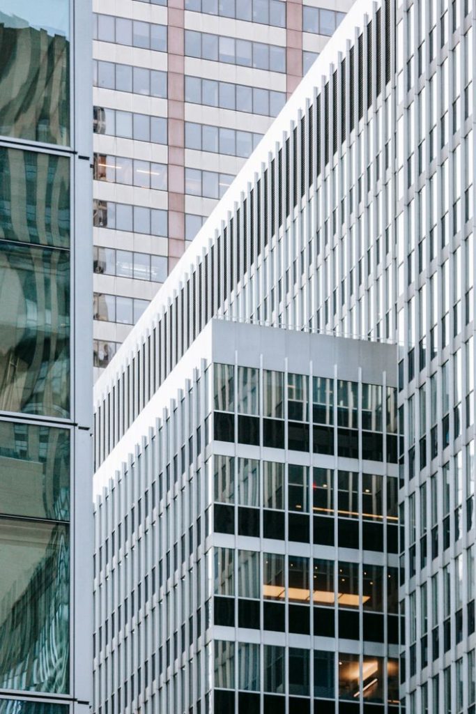 Facades of contemporary buildings with glass walls located in downtown of megapolis in daytime