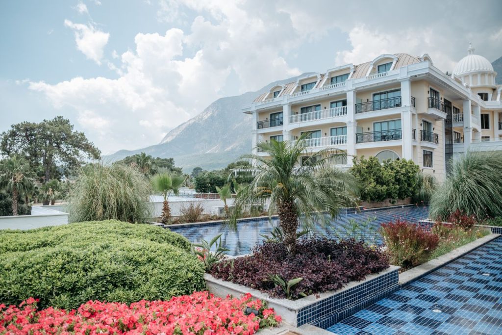 Elegant hotel with gardens, pool, and stunning mountain view, ideal for vacations.